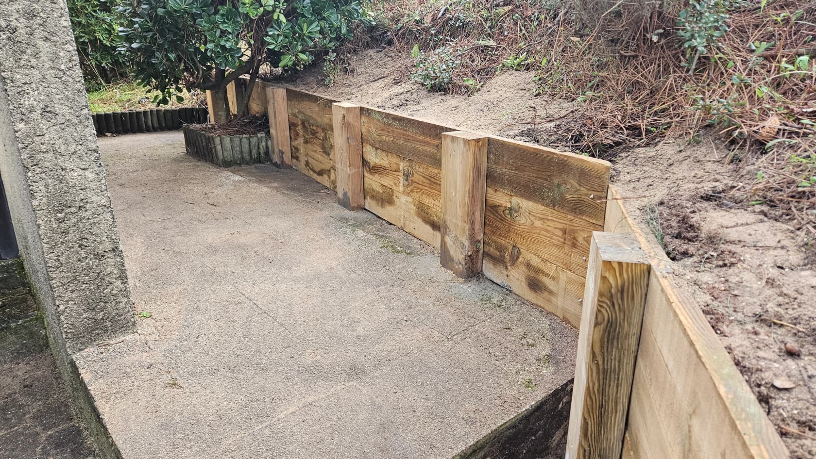 Mur de soutènement en bois type berlinoise le long d’une terrasse